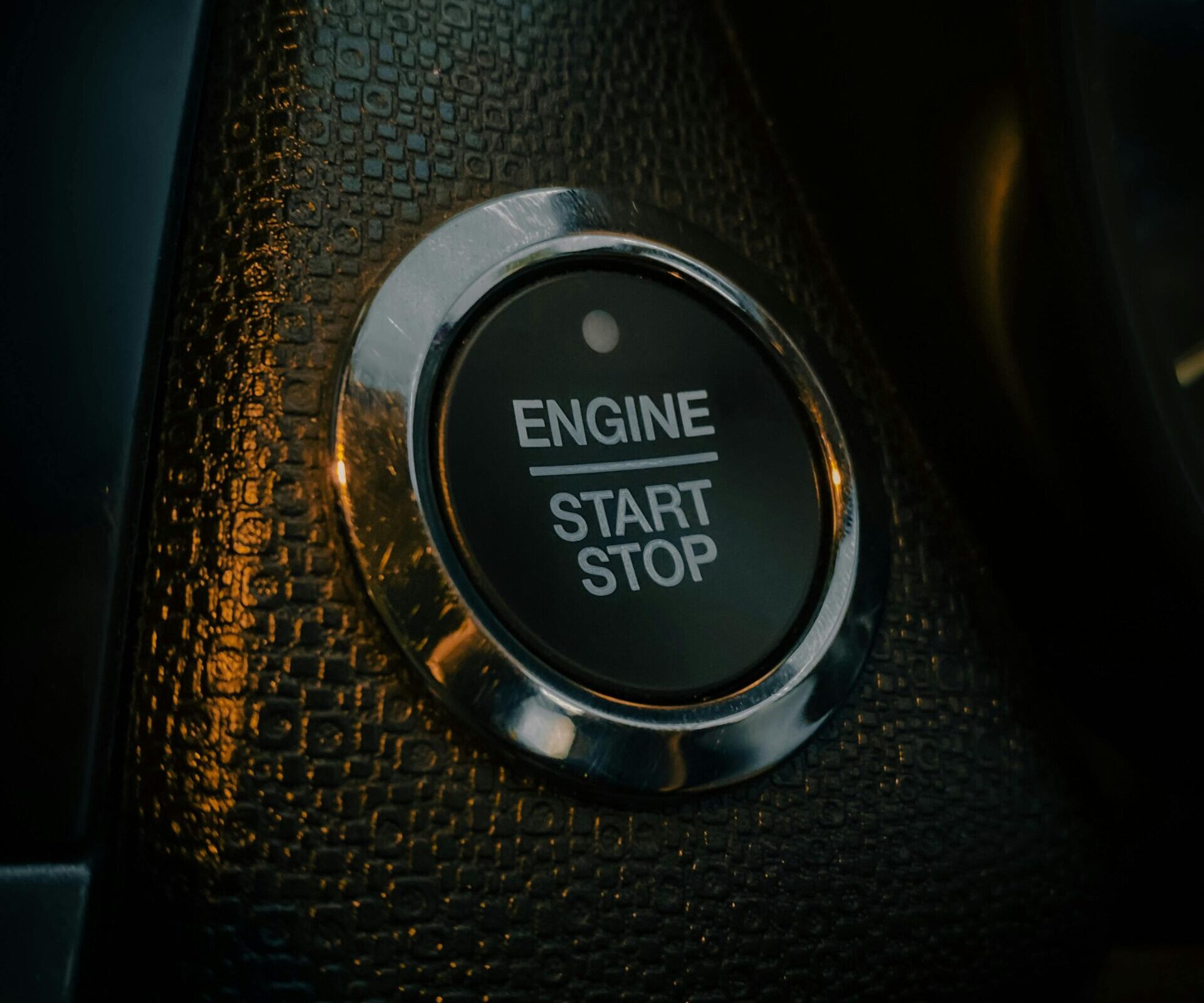 Detailed view of a car's engine start-stop button, highlighting vehicle technology and design in Munnar, India.