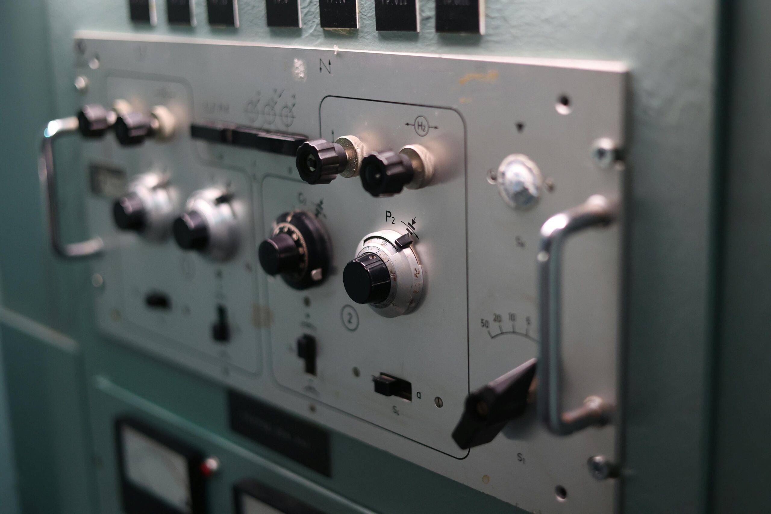 Detailed view of switches and dials on an industrial control panel, showcasing engineering complexity.