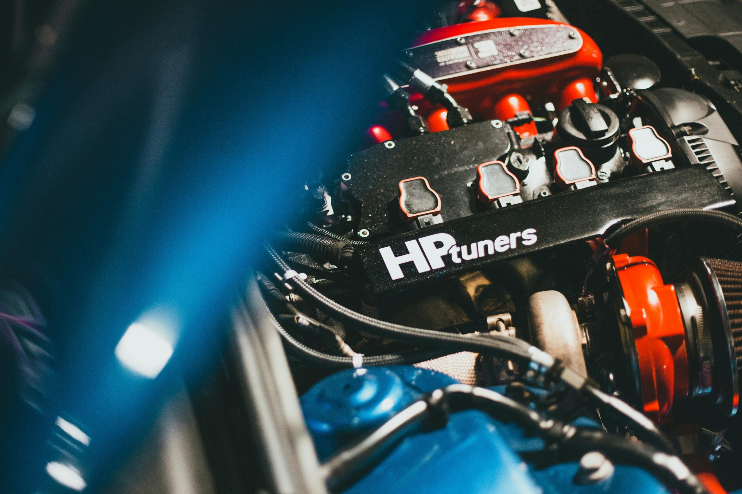 Dynamic close-up of a modern car engine featuring HP Tuners branding, showcasing automotive technology.